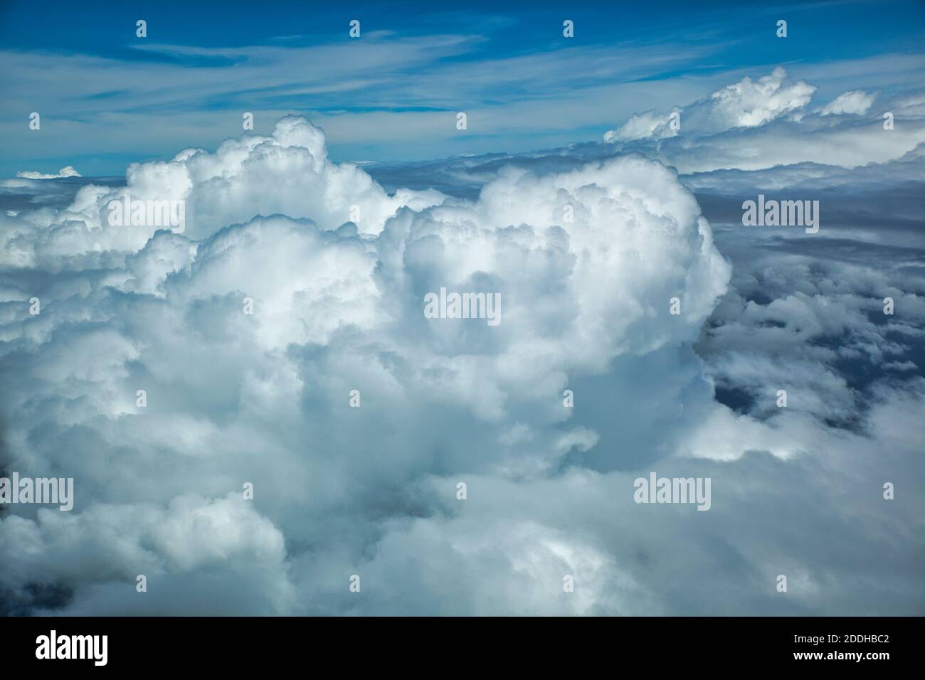 An aerial shot of white fluffy cumulus clouds from above with a blue ...
