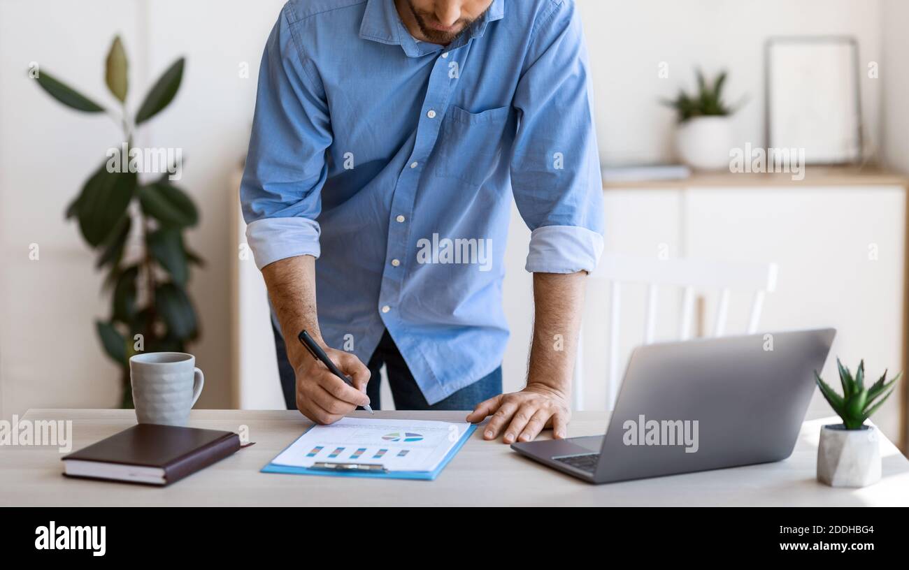 Businessman taking notes to financial report, working with documents at office, cropped Stock Photo