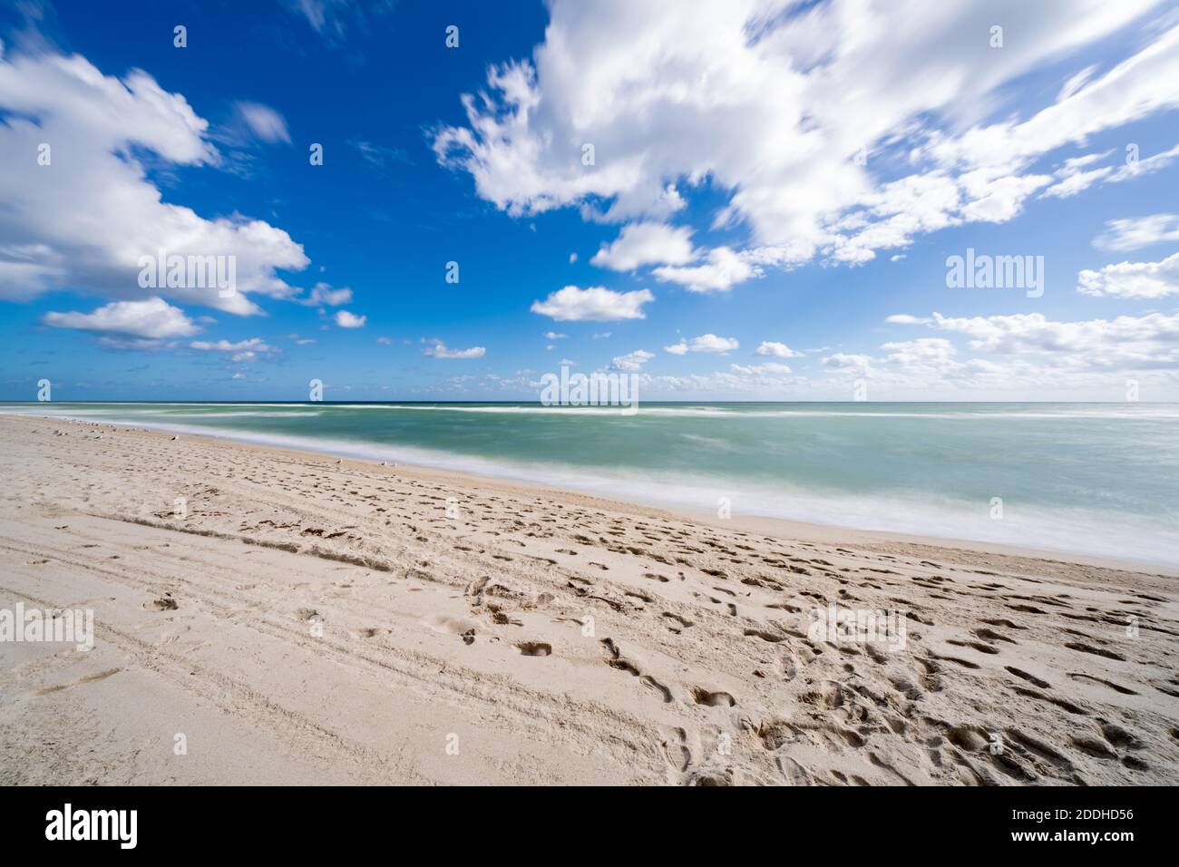 Tropical Beach Scene South Florida sky sand shore clouds blue and green Stock Photo