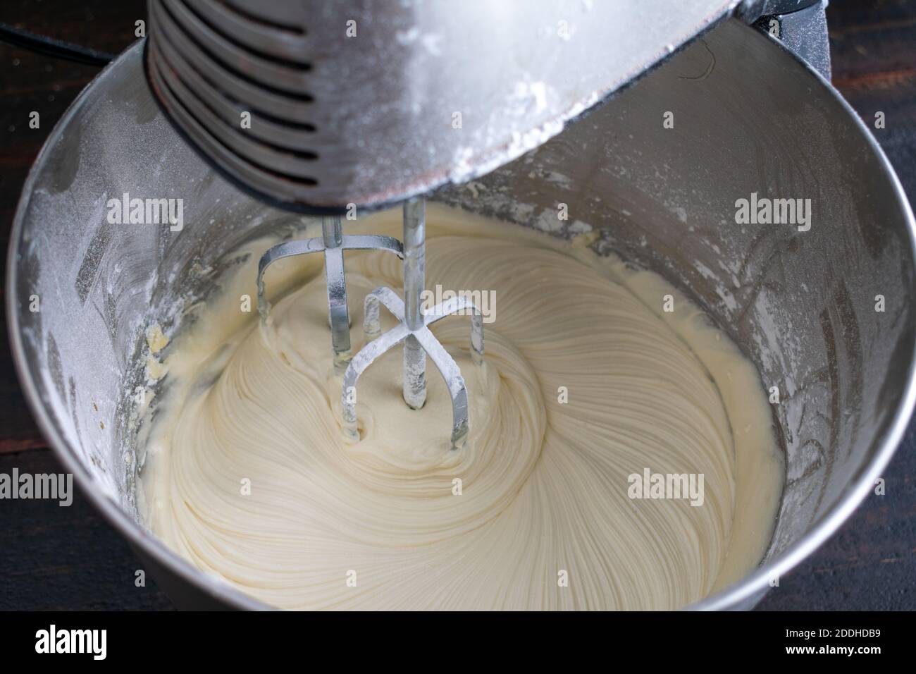 Making White Chocolate Frosting in a Stand Mixer: Beating butter, sugar, and vanilla to make white chocolate icing Stock Photo