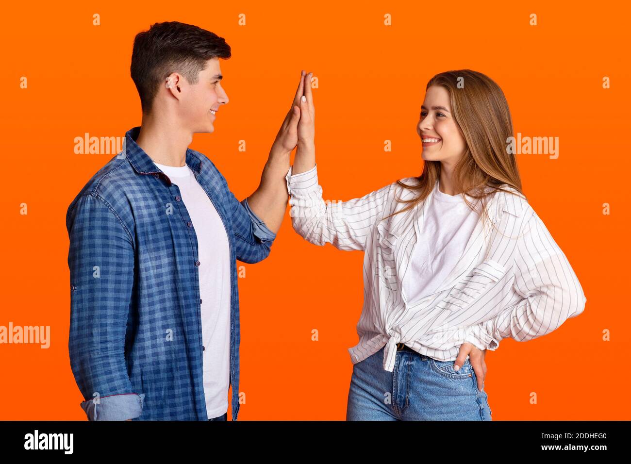 Give a high five and express sincere joy of victory during covid-19 Stock Photo