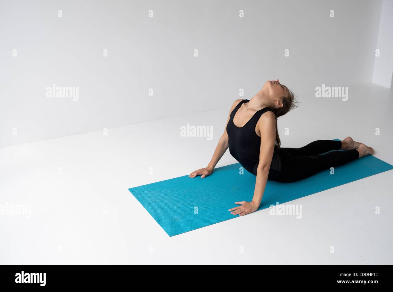 Young woman practicing yoga, lying and stretching in Cobra pose, doing ...