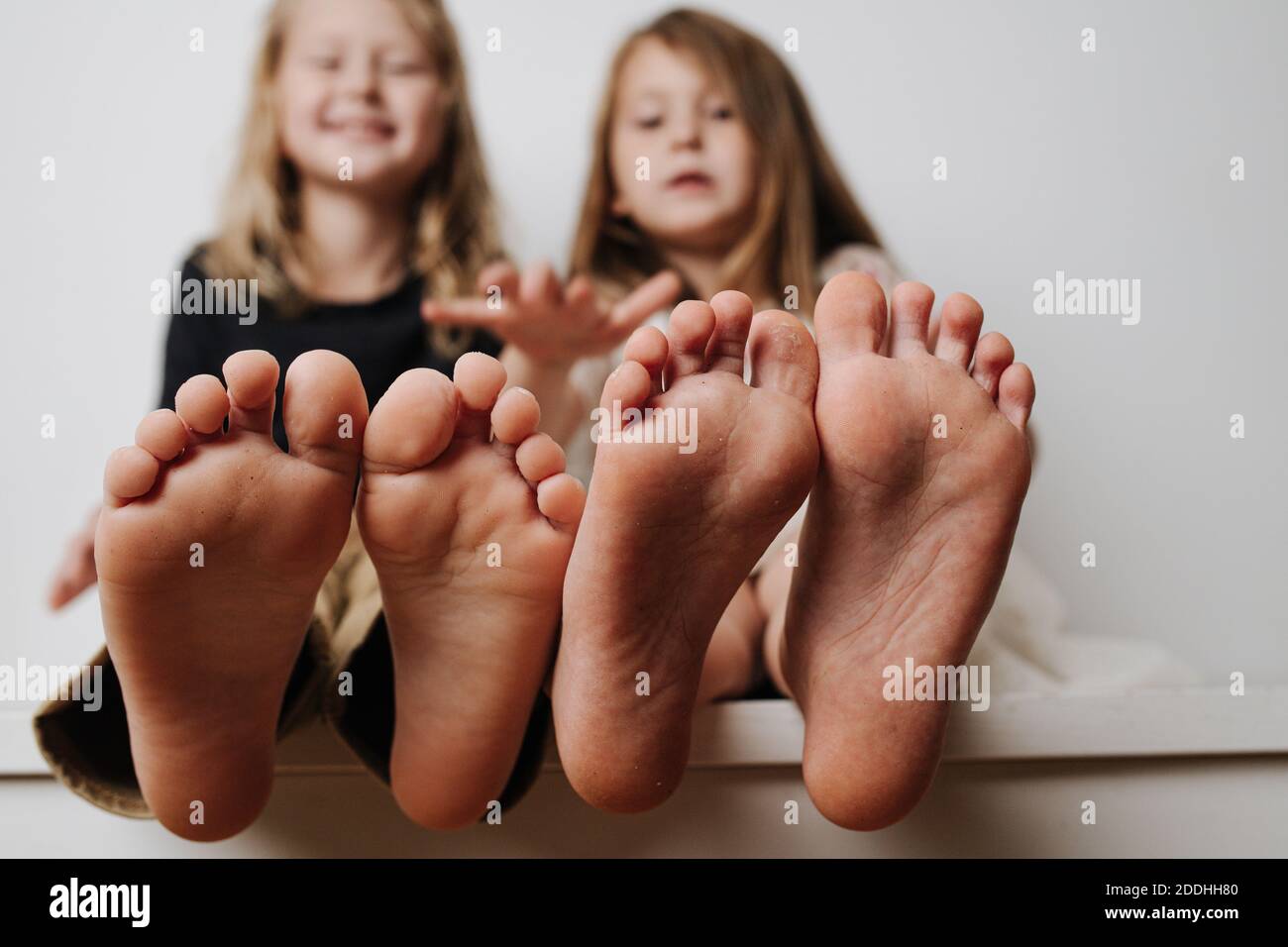 Kids Hold Feet Close Up To The Camera Their Blurred Faces In A kids-hold-feet-close-up-to-the-camera-their-blurred-faces-in-a