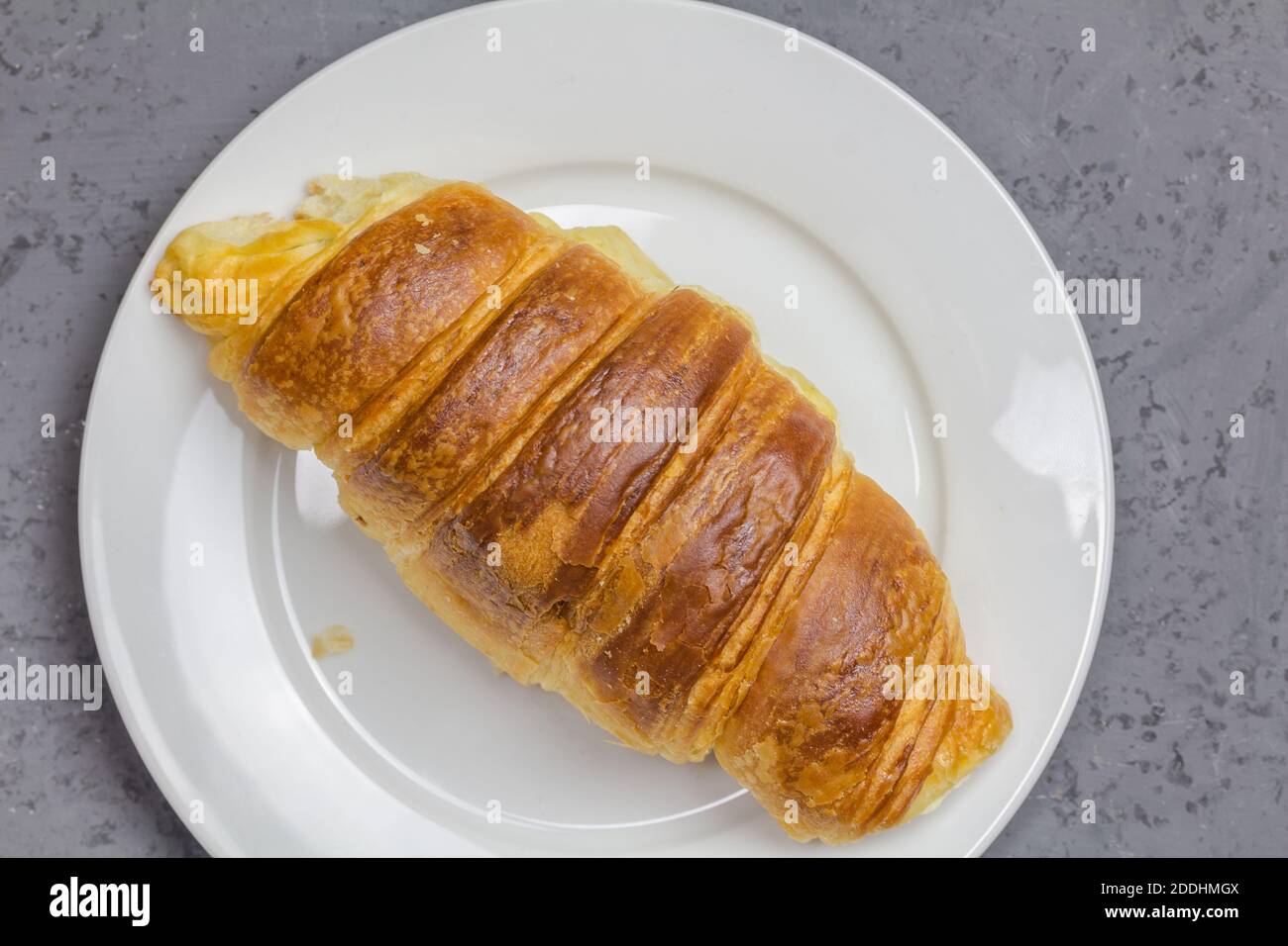Croissant on white plate with copy space - top view close up image Stock Photo