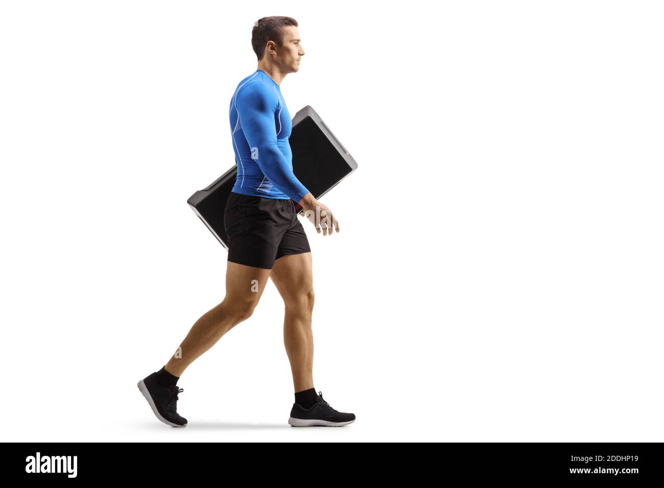 Full length profile shot of a fit man walking and carrying an aerobic  stepper isolated on white background Stock Photo - Alamy
