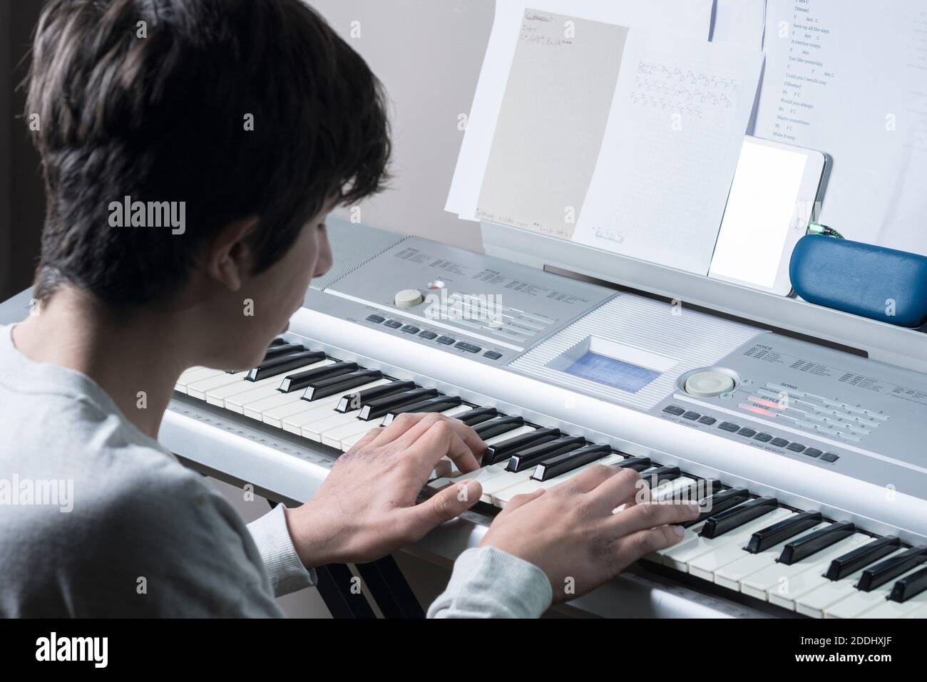 Teenage boy plays electronic keyboard piano Stock Photo