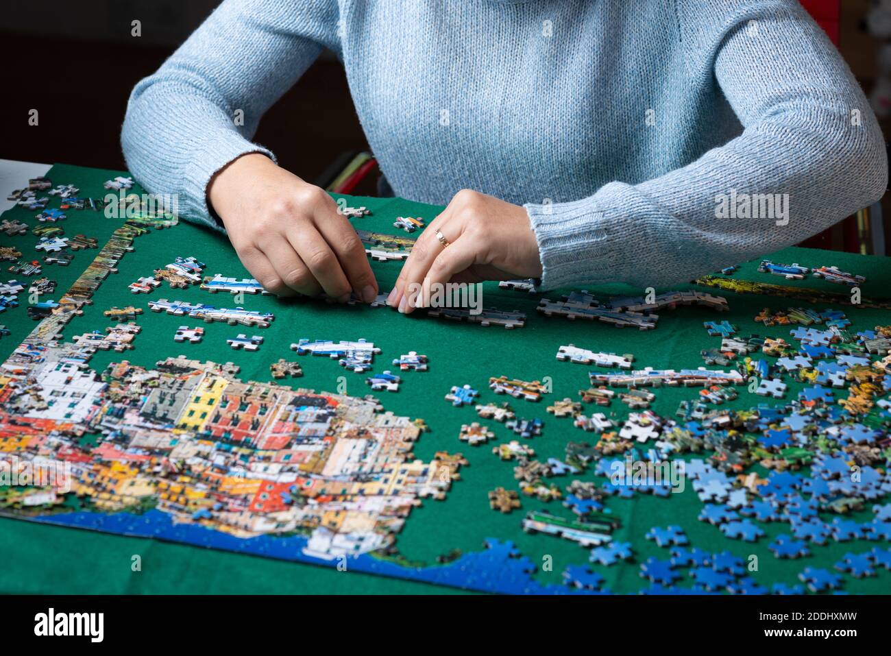 Woman works on a jigsaw puzzle Stock Photo