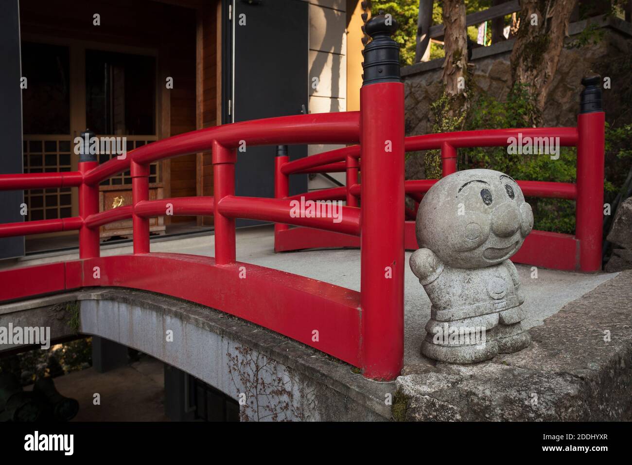 Vertical view of a red bridge with the cartoon character Anpanman in Daisho-in Buddhist temple, Miyajima, Japan Stock Photo