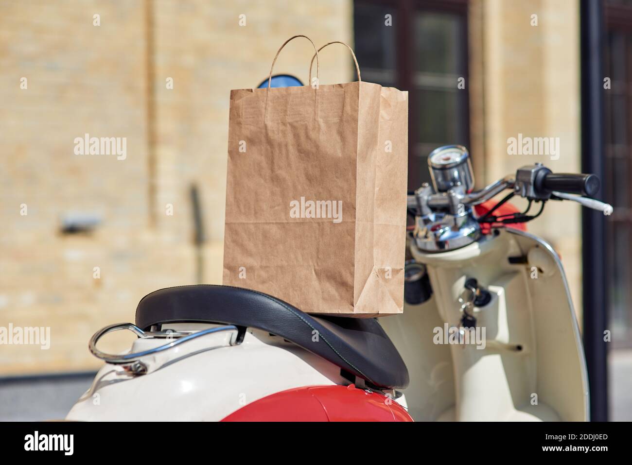 Express delivery. Paper bag on scooter standing on the city street