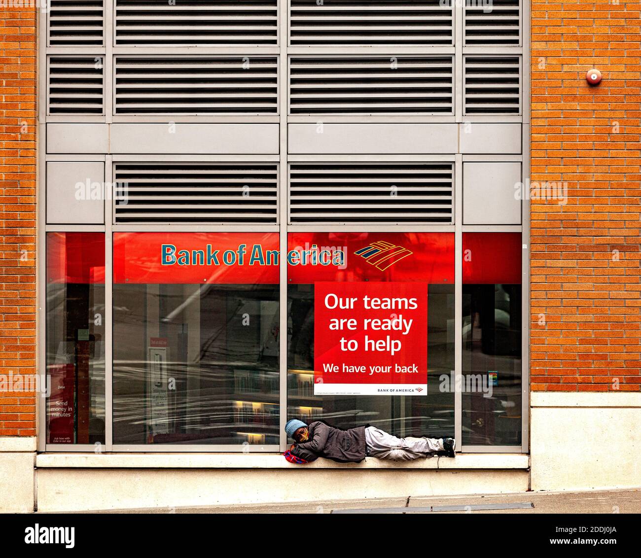 WA17747-00.....WASHINGTON - Homeless woman sleeps in a shelf in front of Bank America in Seattle. Stock Photo