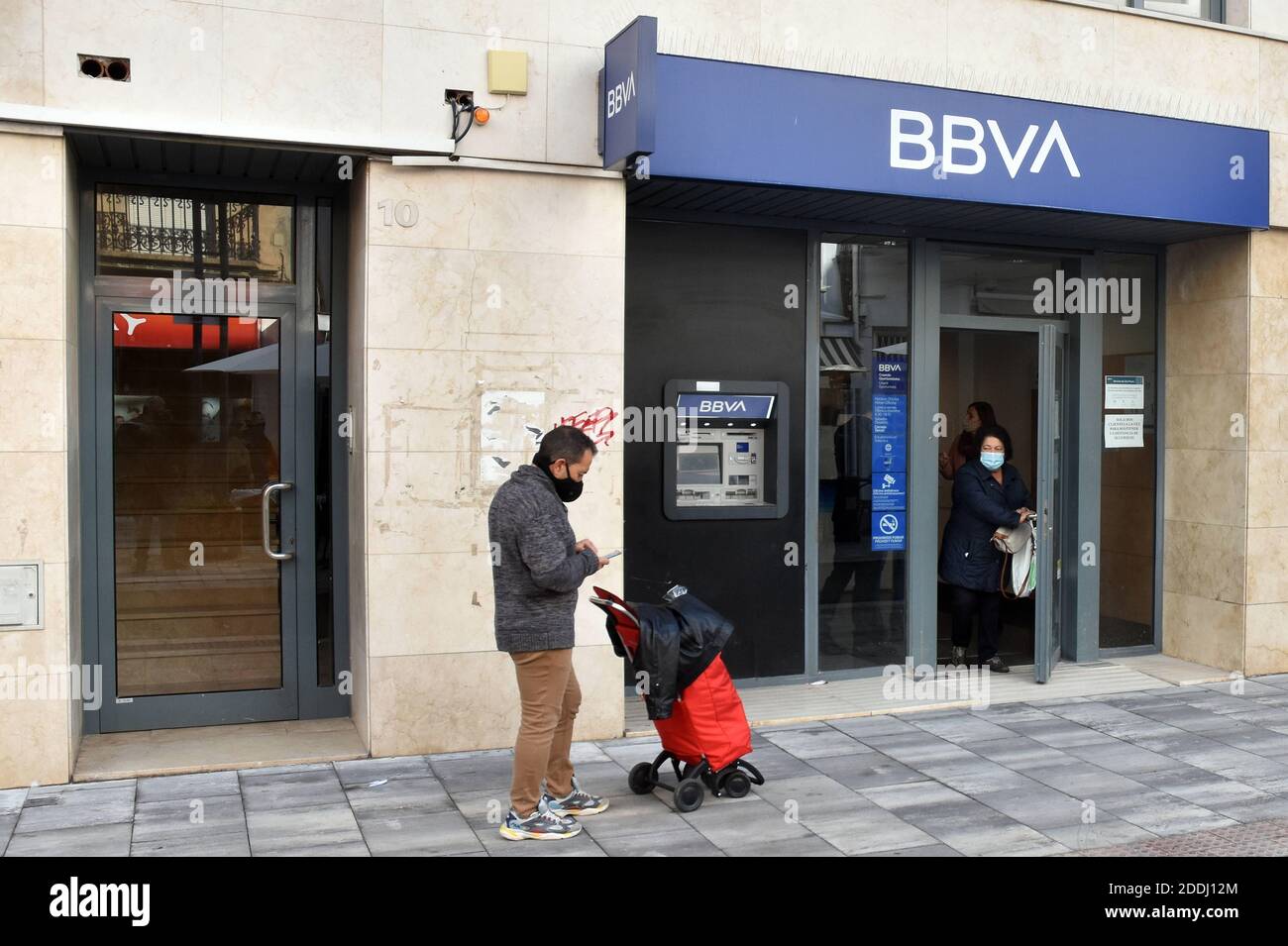 Vendrell, Catalonia, Spain. 20th Mar, 2020. A man waits at a social distance to enter a bank branch of the BBVA bank in Vendrell Tarragona.The merging of BBVA (Bank Bilbao Vizcaya Argentaria) and Sabadell Bank would create the second banking giant of almost 600,000 million in the Spanish market by volume of assets, only behind the entity that resulted from the merging of CaixaBank and Bankia. Credit: Ramon Costa/SOPA Images/ZUMA Wire/Alamy Live News Stock Photo