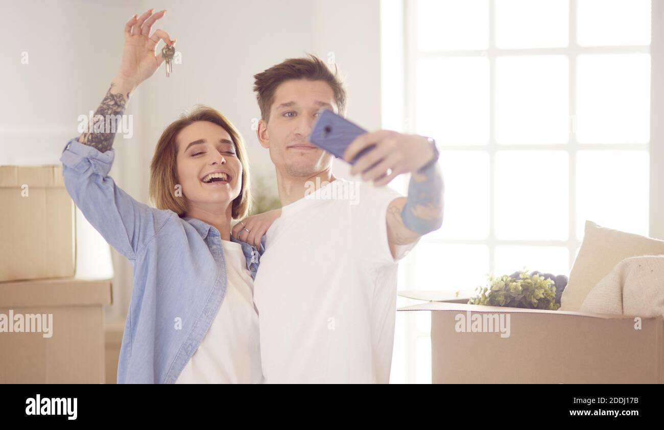 Happy smiling young couple showing a pair of keys of their new house ...