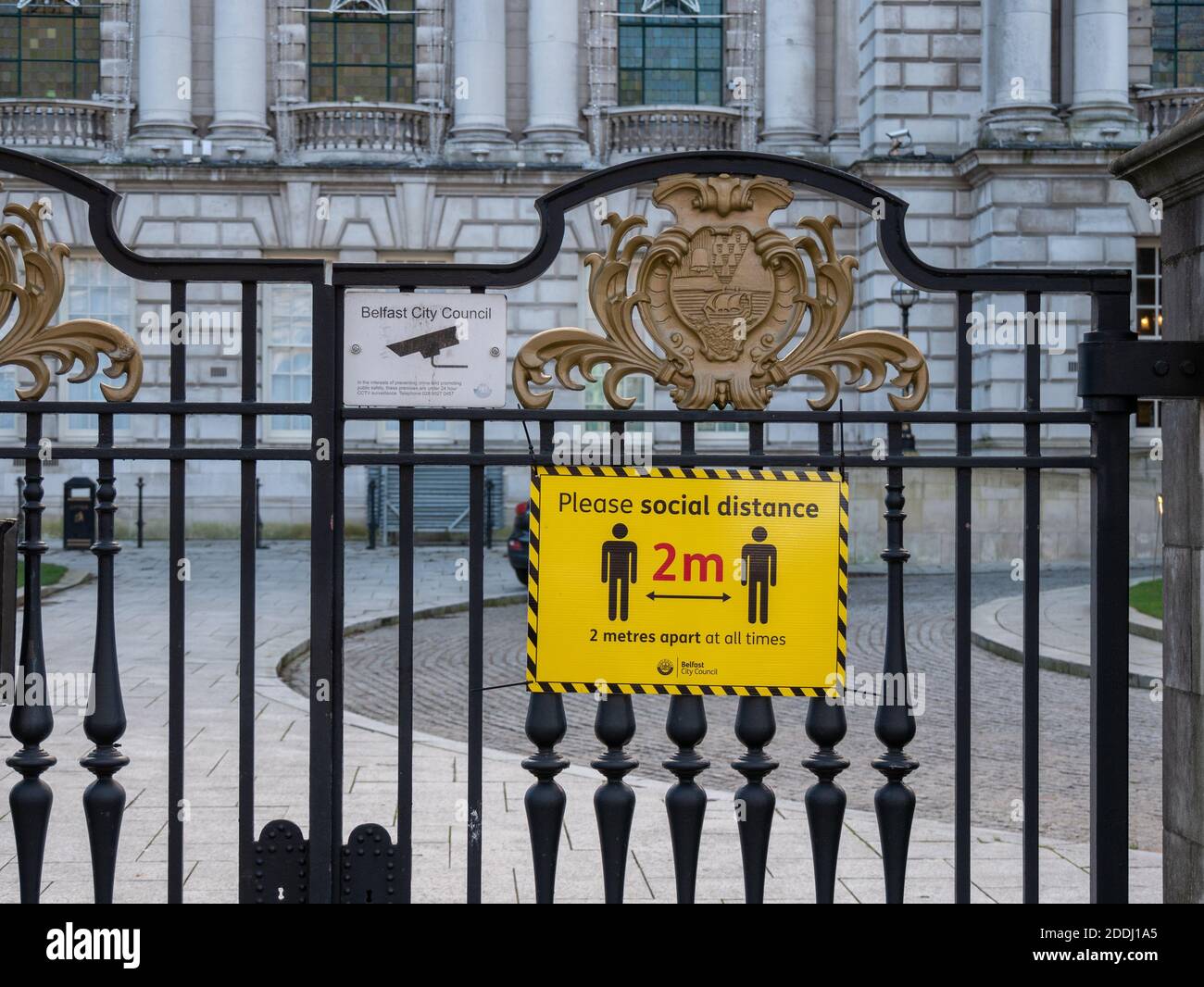 Belfast, Northern Ireland, UK, 25 November 2020: Sign on the gates to Belfast City Hall reminding people of social distancing and to stay 2 metres apart Stock Photo