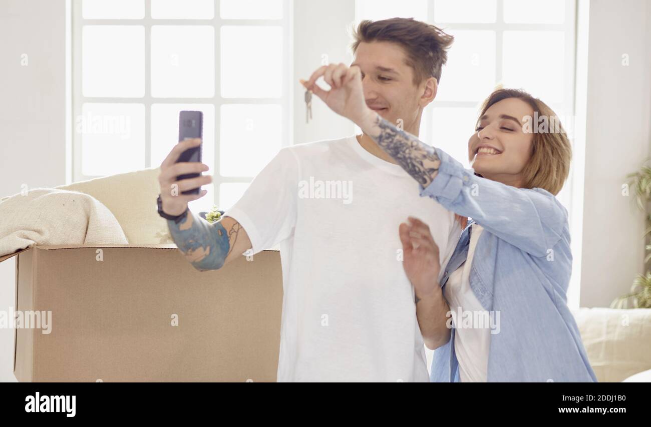Happy smiling young couple showing a pair of keys of their new house ...