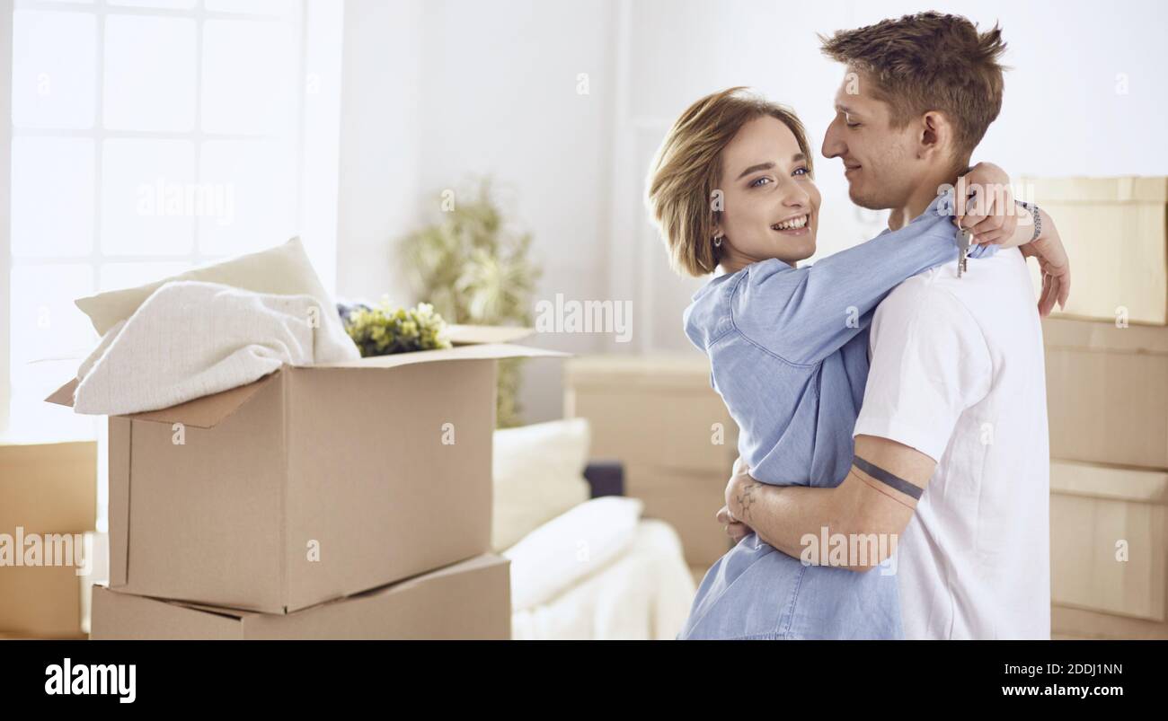 Happy smiling young couple showing a pair of keys of their new house ...