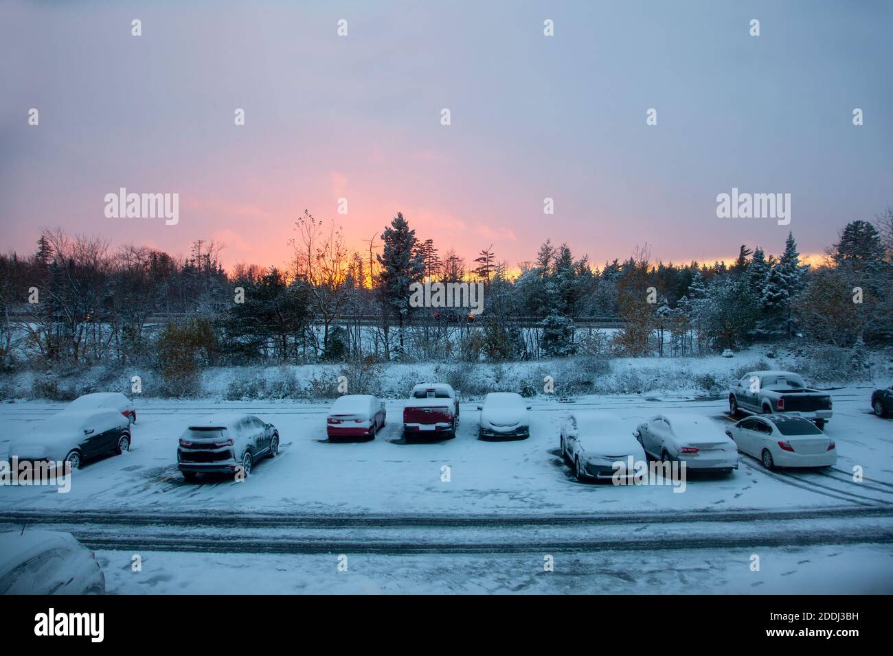cars parked in a lot outside a building during a frosty beautiful winter sunset Stock Photo