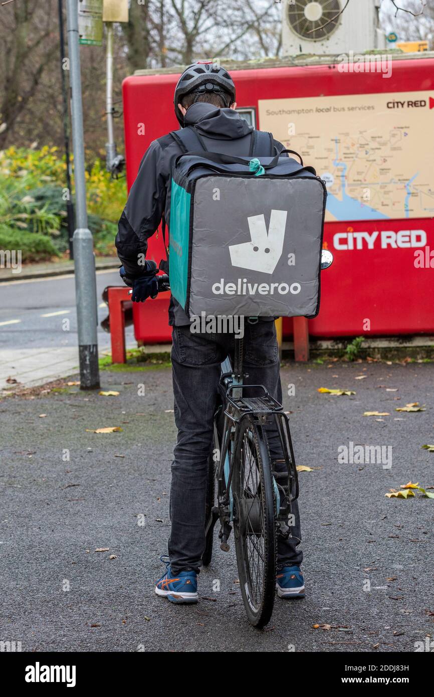 a deliveroo bicycle delivery rider waiting for an order. Stock Photo