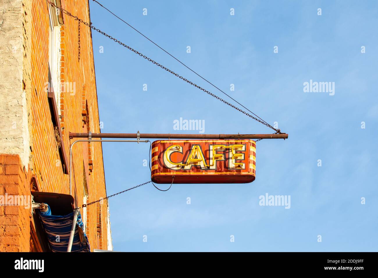 Vintage hanging metal café sign with neon lighting. Stock Photo