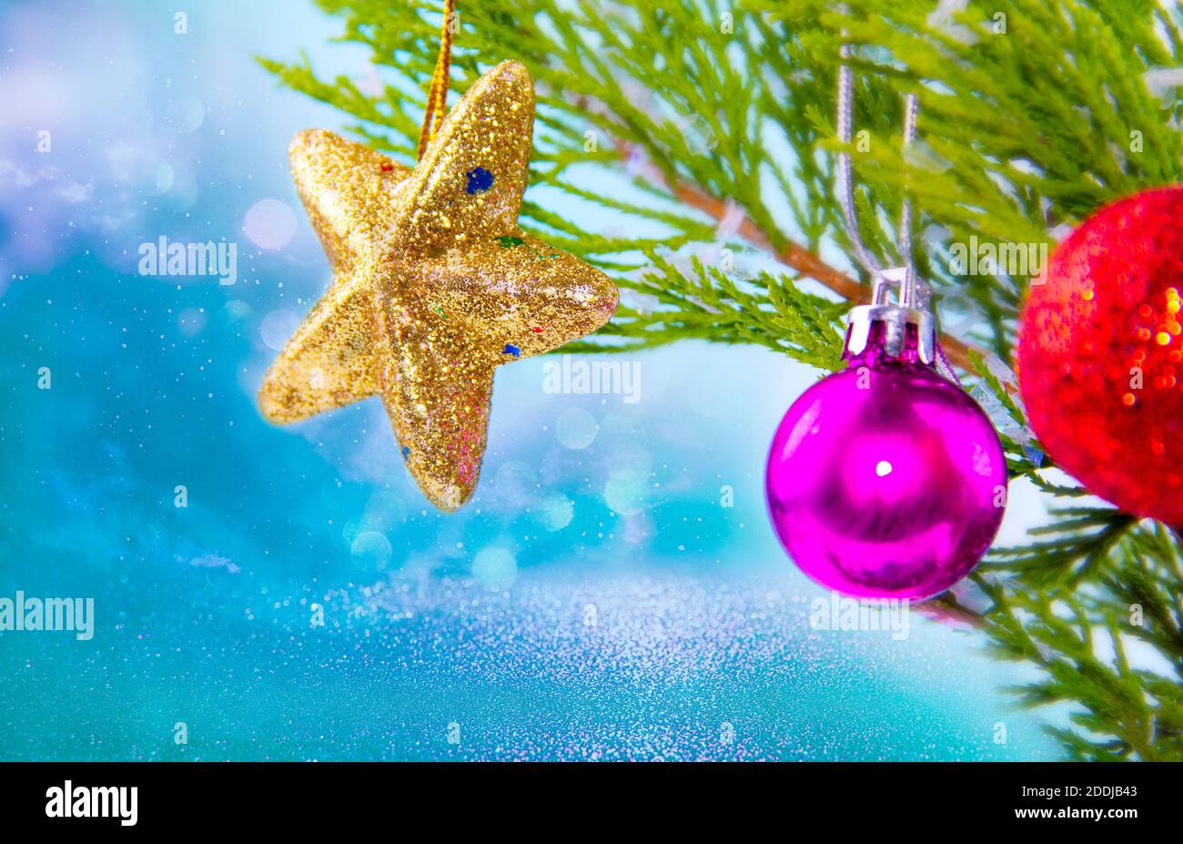 shiny golden star christmas ornament hanging on snowy pine tree branch ...