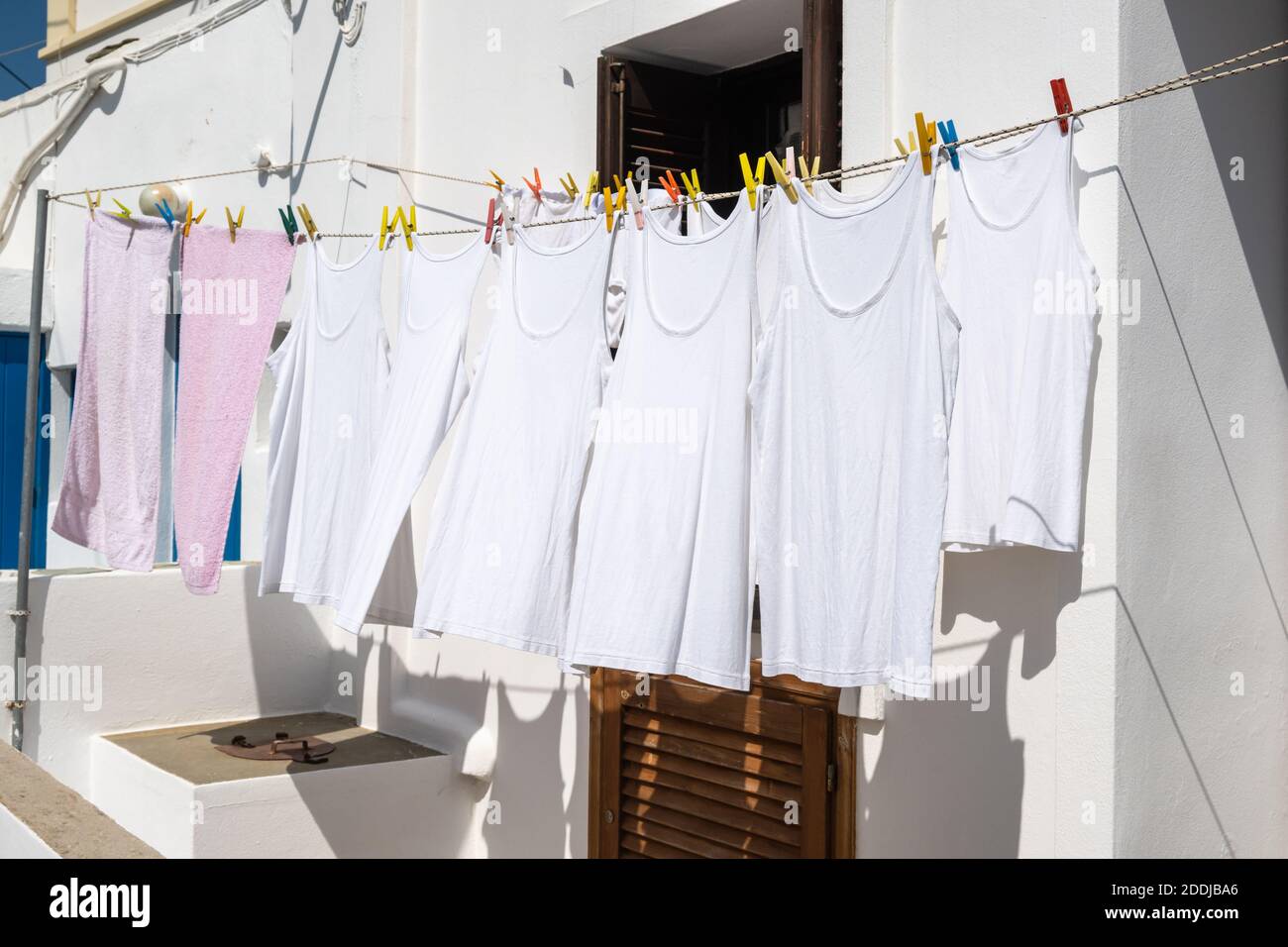 Clothes drying in the sun on a street in Greece Stock Photo