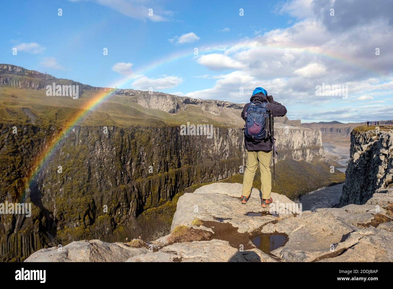 A photographer takes pictures over a canyon near Detifoss waterfall, Iceland's golden ring. Stock Photo