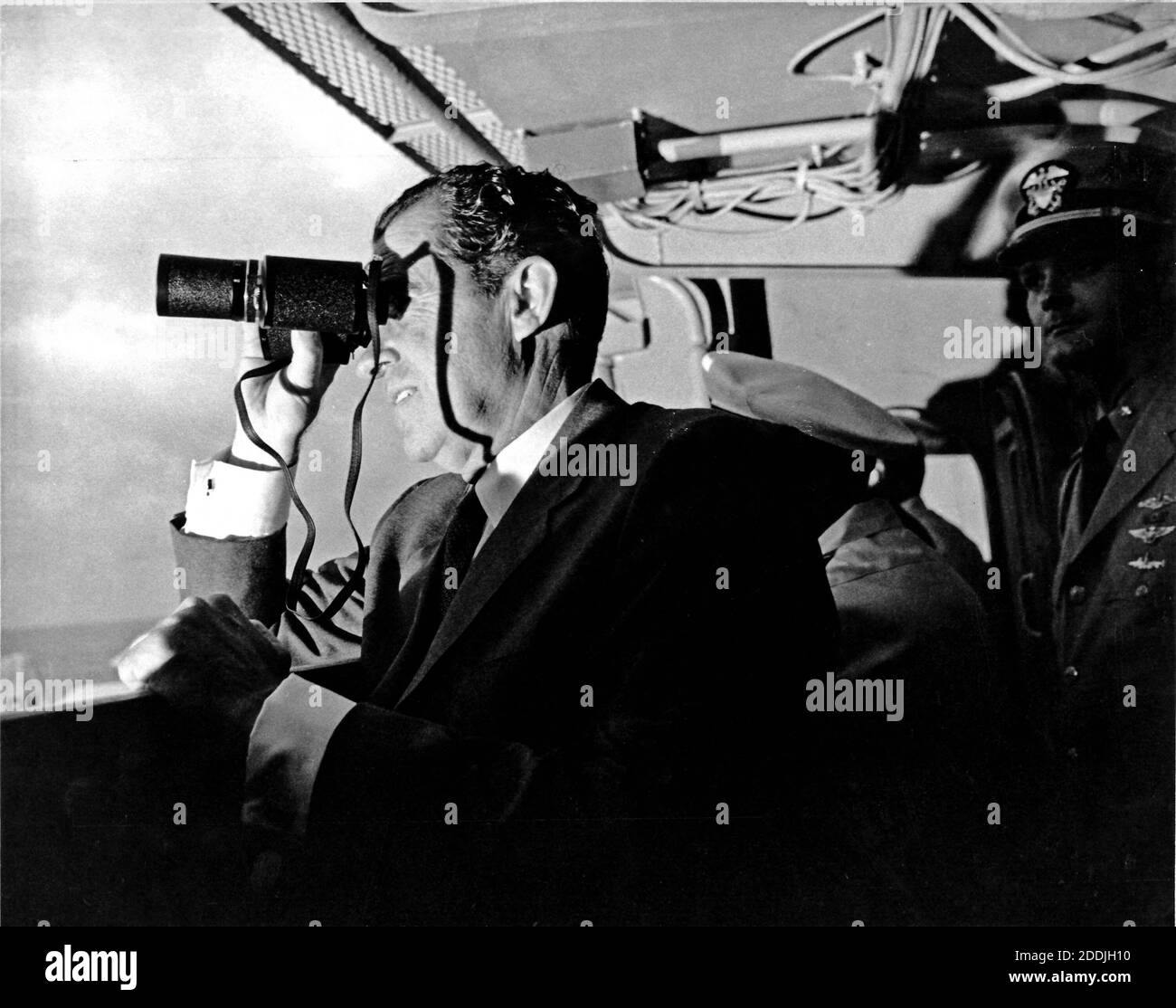 Aboard the USS Hornet - (FILE) -- United States President Richad M. Nixon follows Apollo 11 recovery activities with binoculars aboard the USS Hornet, located 13 miles (20.9215 km) from the spacecraft's splashdown point. The President led the nation in greeting astronauts Neil A. Armstrong, Michael Collins, and Edwin E. Aldrin, Jr., at the successful completion of their historic lunar landing mission on July 24, 1969. Their spacecraft splashed down 900 miles (1448.41 km) southwest of Hawaii at 12:50 p.m. EDT July 24, 1969 eight days after the space pilots were launched by a Saturn V space vehi Stock Photo
