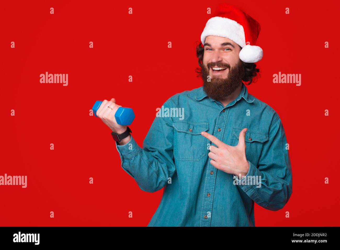 Young bearded man suggests to go to the gym while wearing christmas hat