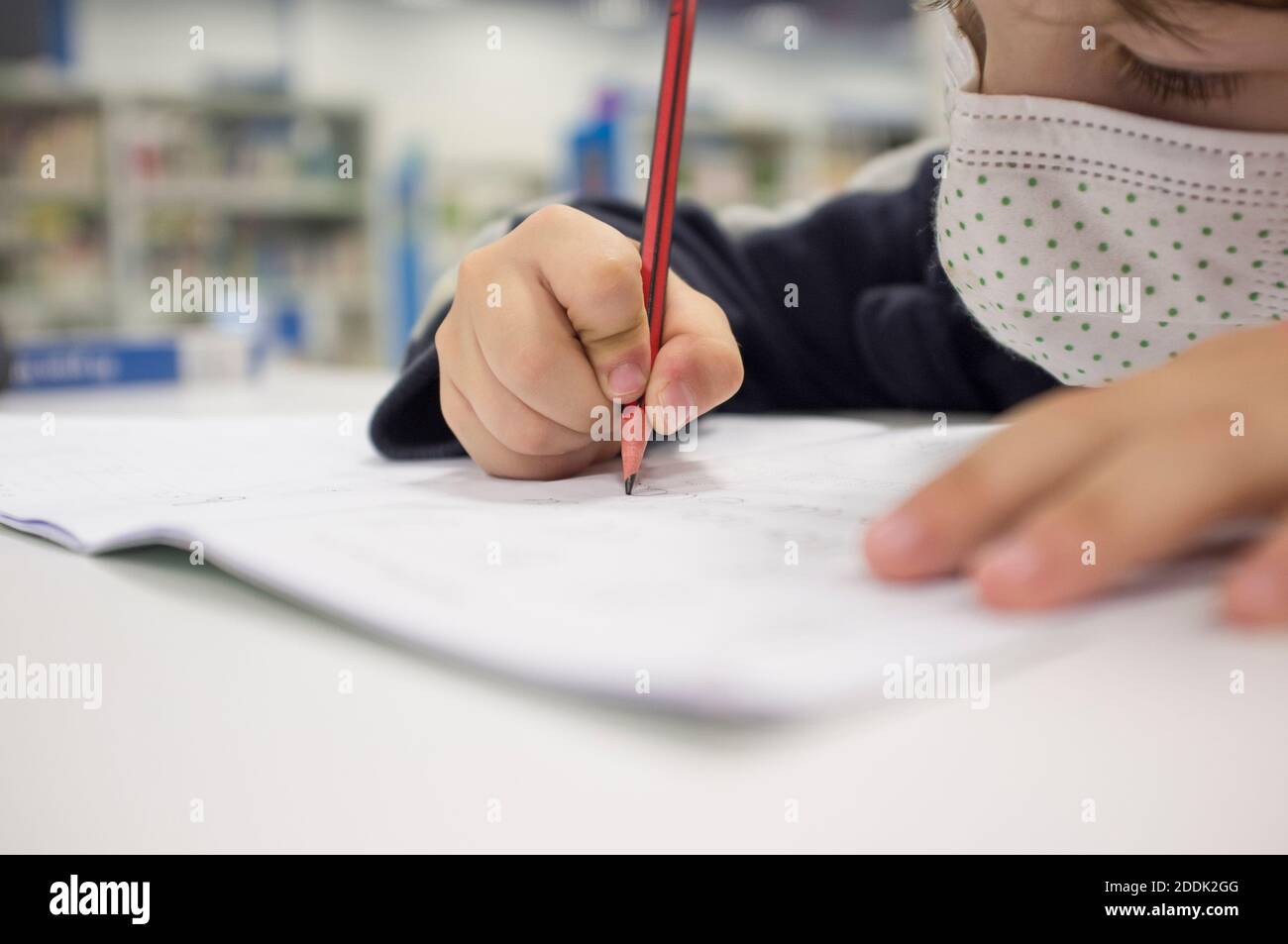 Pre-writter child boy doing calligraphy exercises with booklets. Selective focus Stock Photo