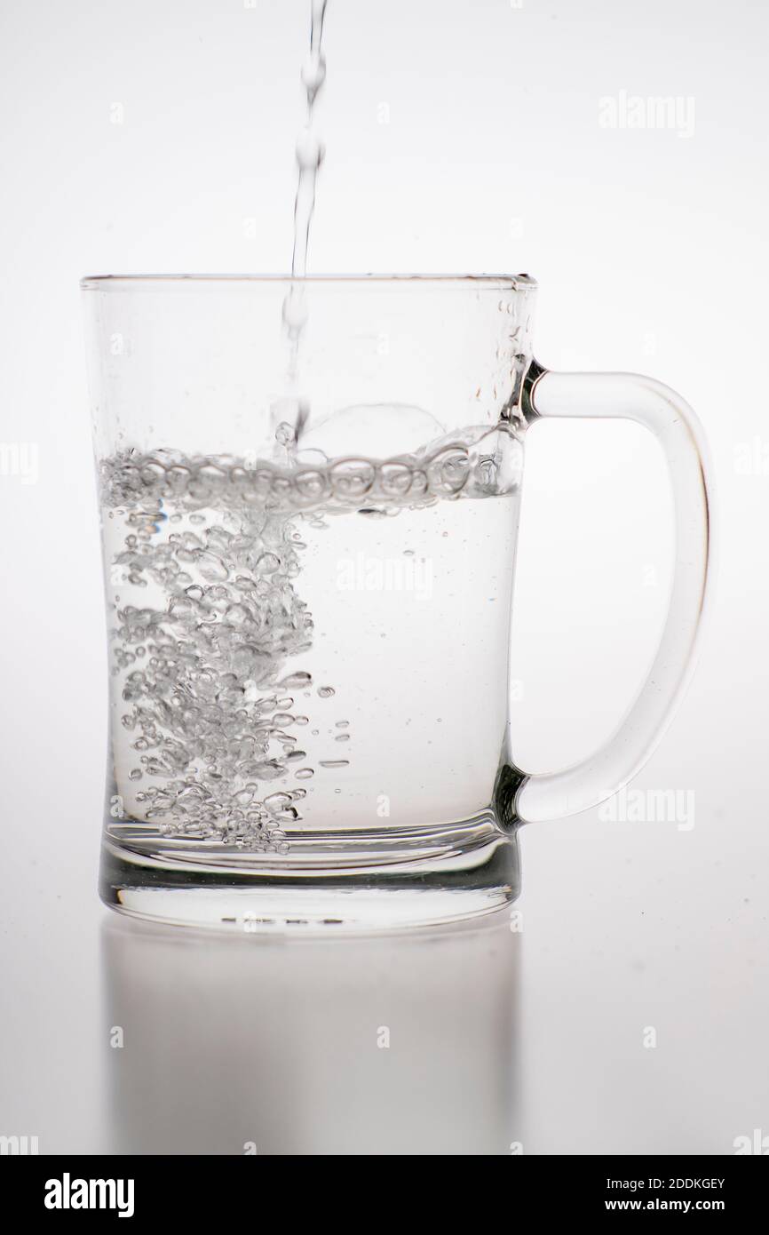 Pouring water into a mug. Glass container for weak carbonated alcohol