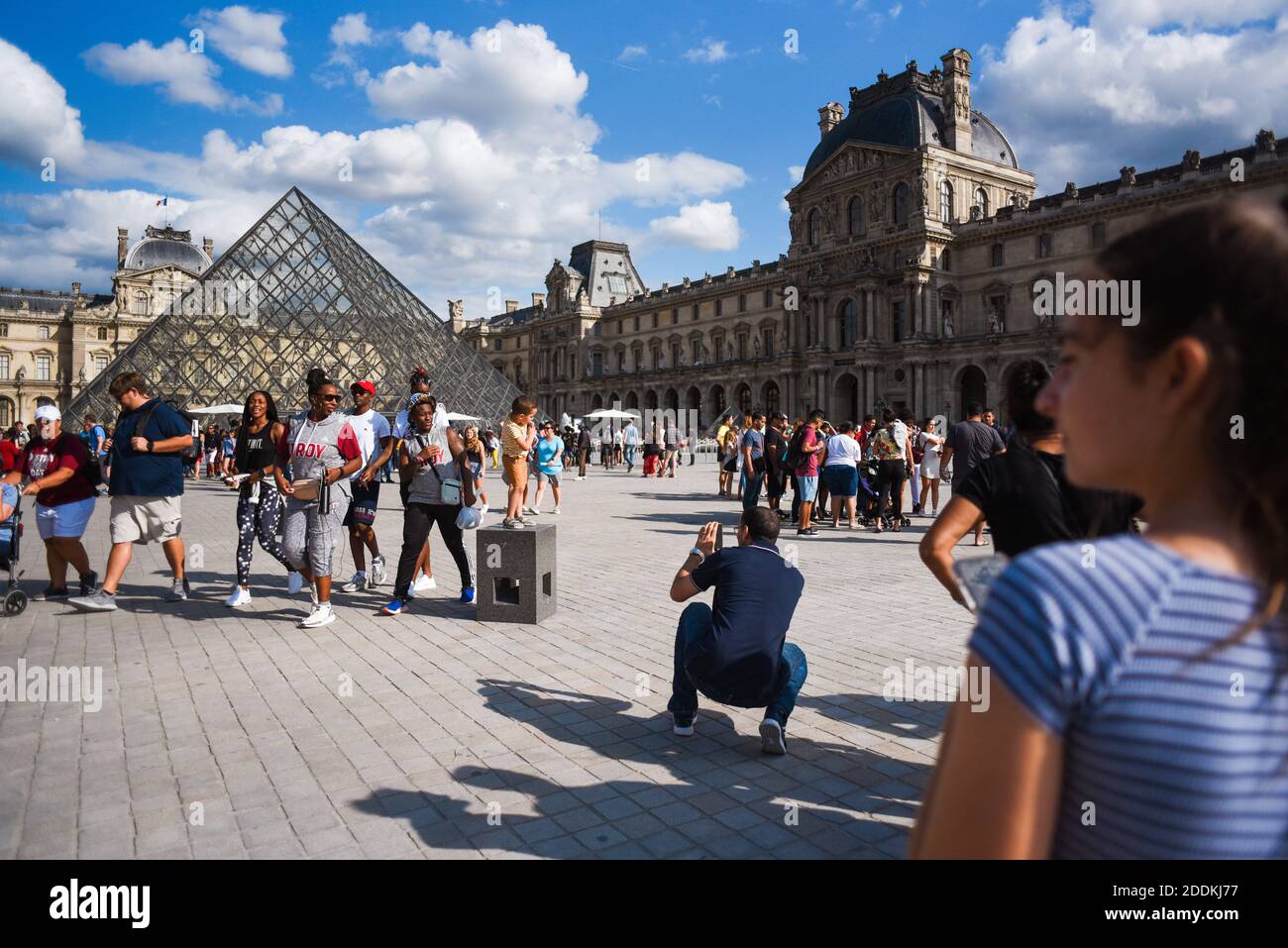Tourists walk in front of the Louvre on July 31 2019 in Paris, France.  Anyone planning a visit to Paris' Louvre museum has been warned to book in  advance - as the