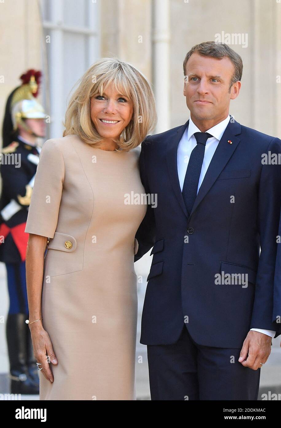 French President Emmanuel Macron and his wife Brigitte Macron wait for the  arrival of the Greek Prime Minister prior to a meeting at the Elysee Palace  in Paris on August 22, 2019.