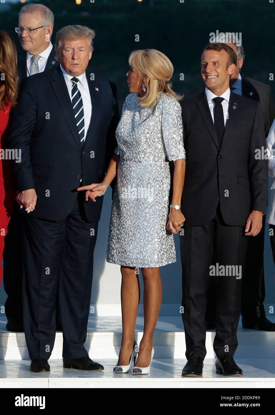 Brigitte Macron gives a kiss to US President Donald Trump as her ...