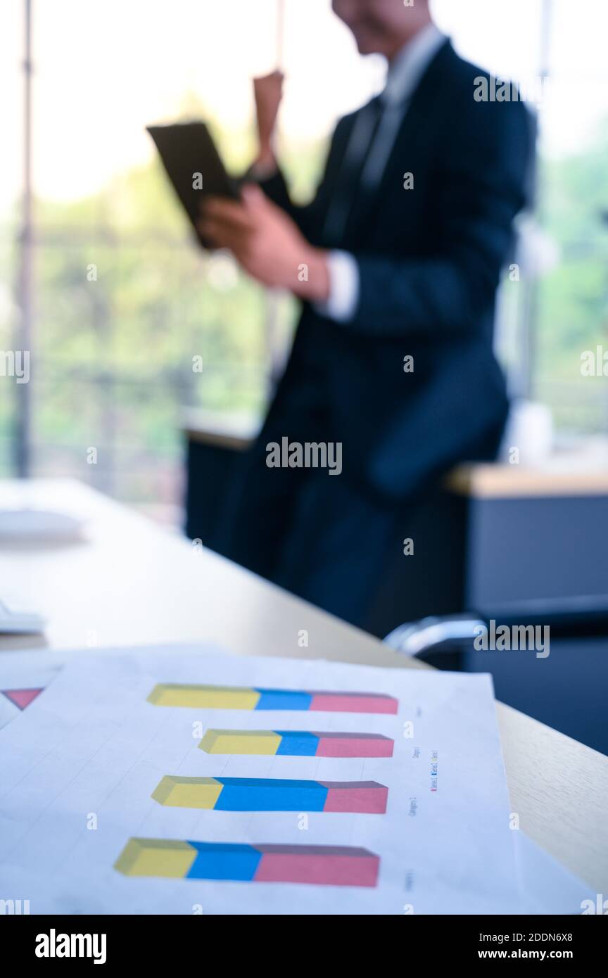 Businessman with graph paper at office workplace. Business management concept. Stock Photo