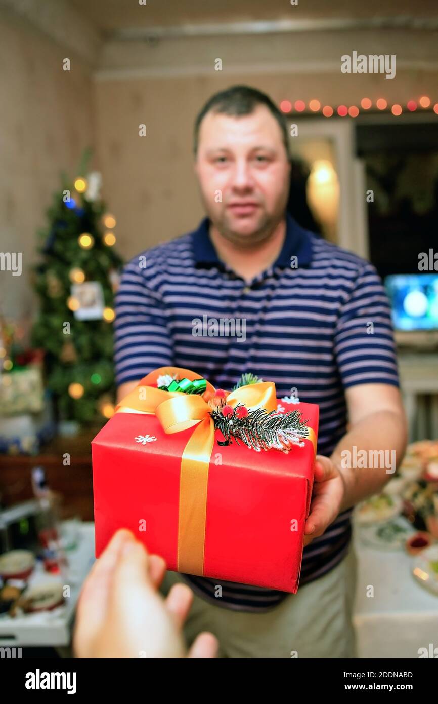 Young man holds out presents new year beautiful gift box Stock Photo