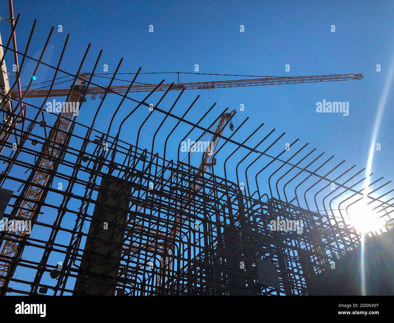 Tower cranes against blue sky. Lifting machinery at construction site Stock Photo