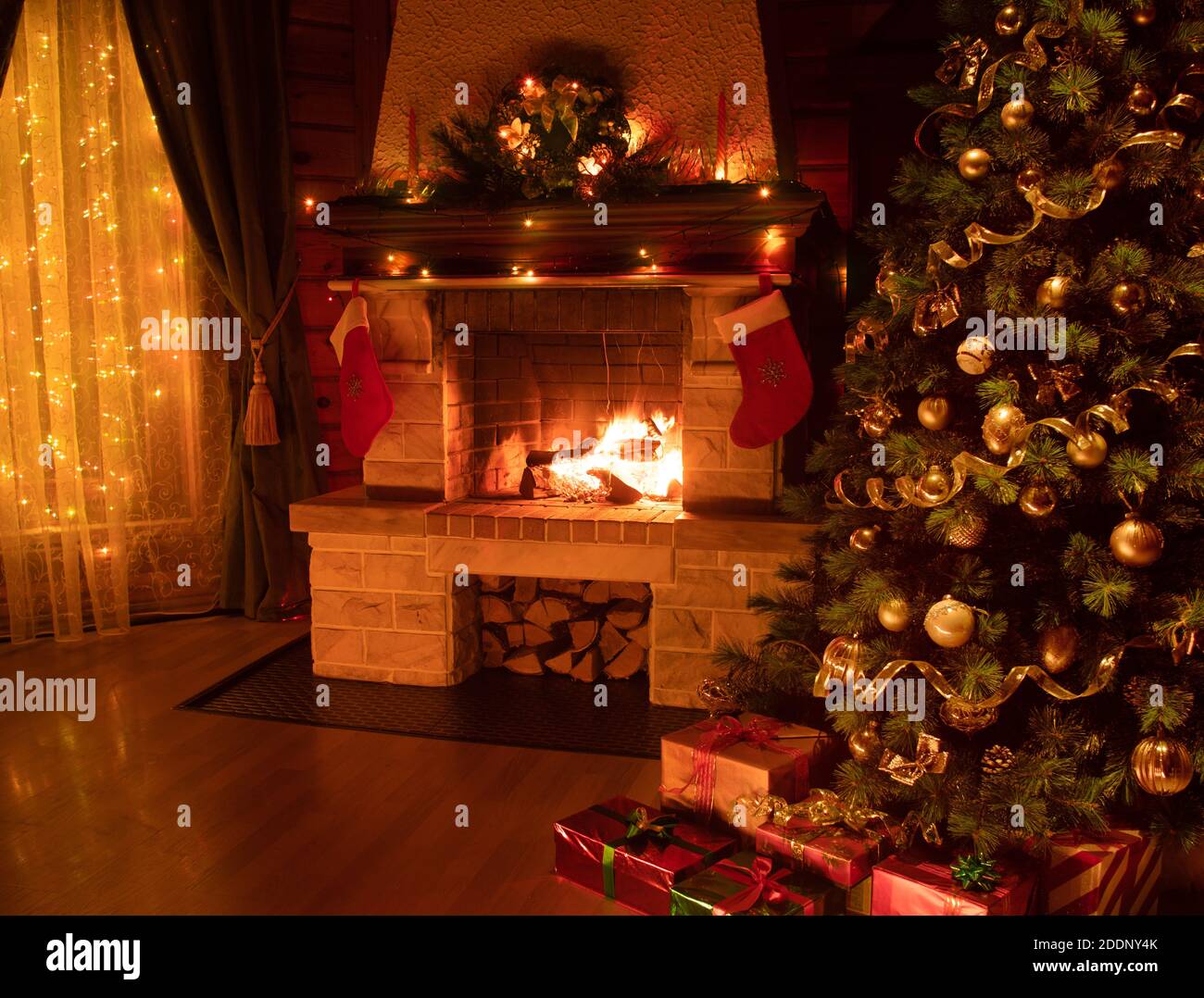 Christmas decorated tree in dark interior with fireplace and window ...