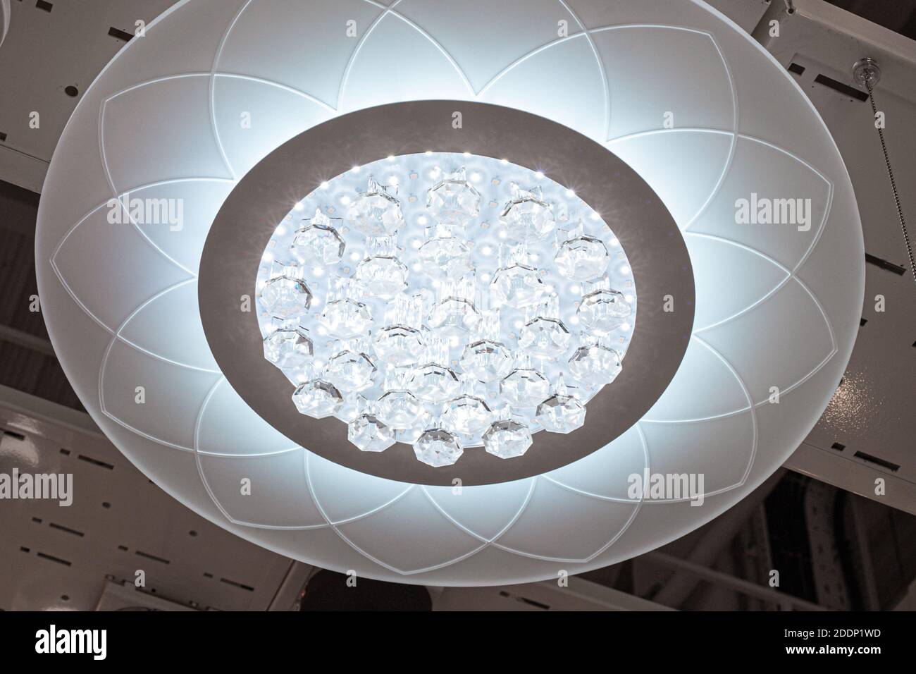 beautiful round chandelier with crystals hanging on the ceiling Stock