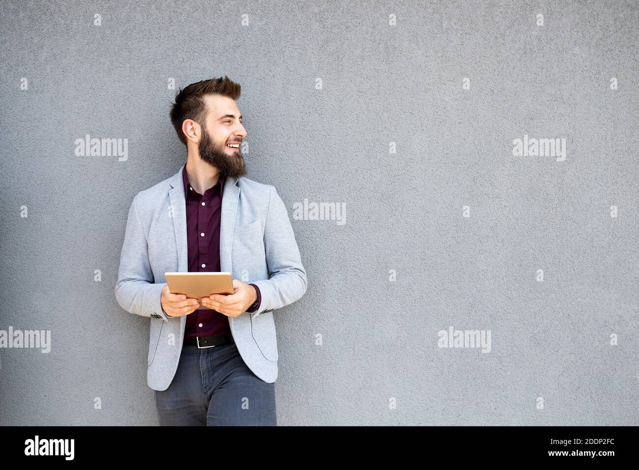 Young businessman holding tablet in hands outdoor Stock Photo