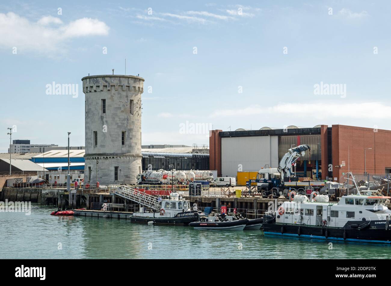 Portsmouth, UK - September 8, 2020: Ships moored near the historic Round Tower at the Royal Navy Base in Portsmouth Harbour, Hampshire on a sunny day. Stock Photo