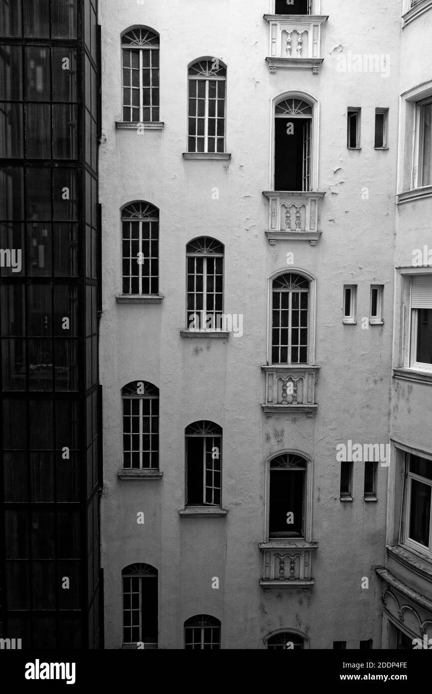 Black and white view of the front facade with multiple windows of an old tenement house in Budapest Stock Photo