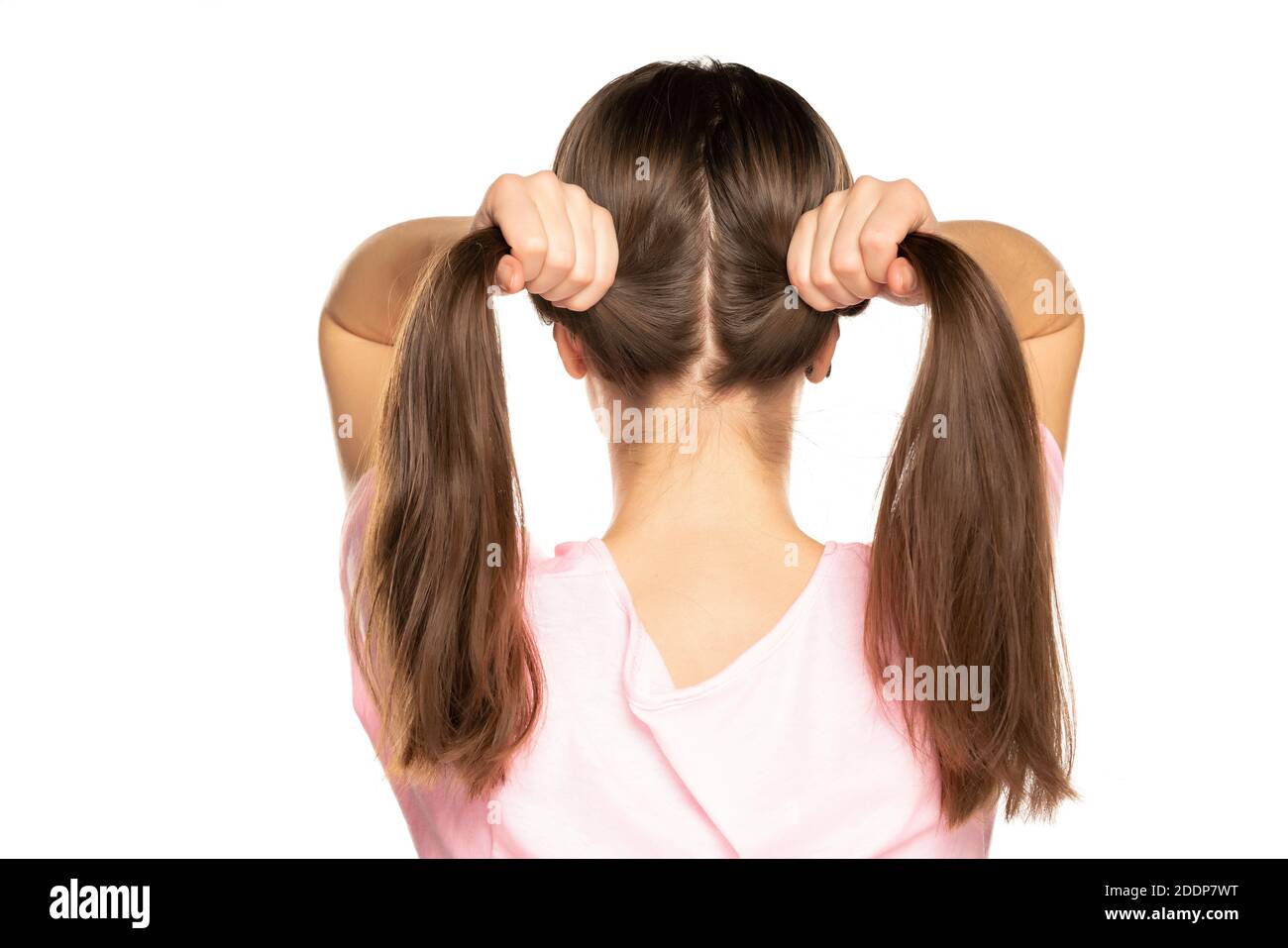 Back view of young woman with ponytails on white background Stock Photo