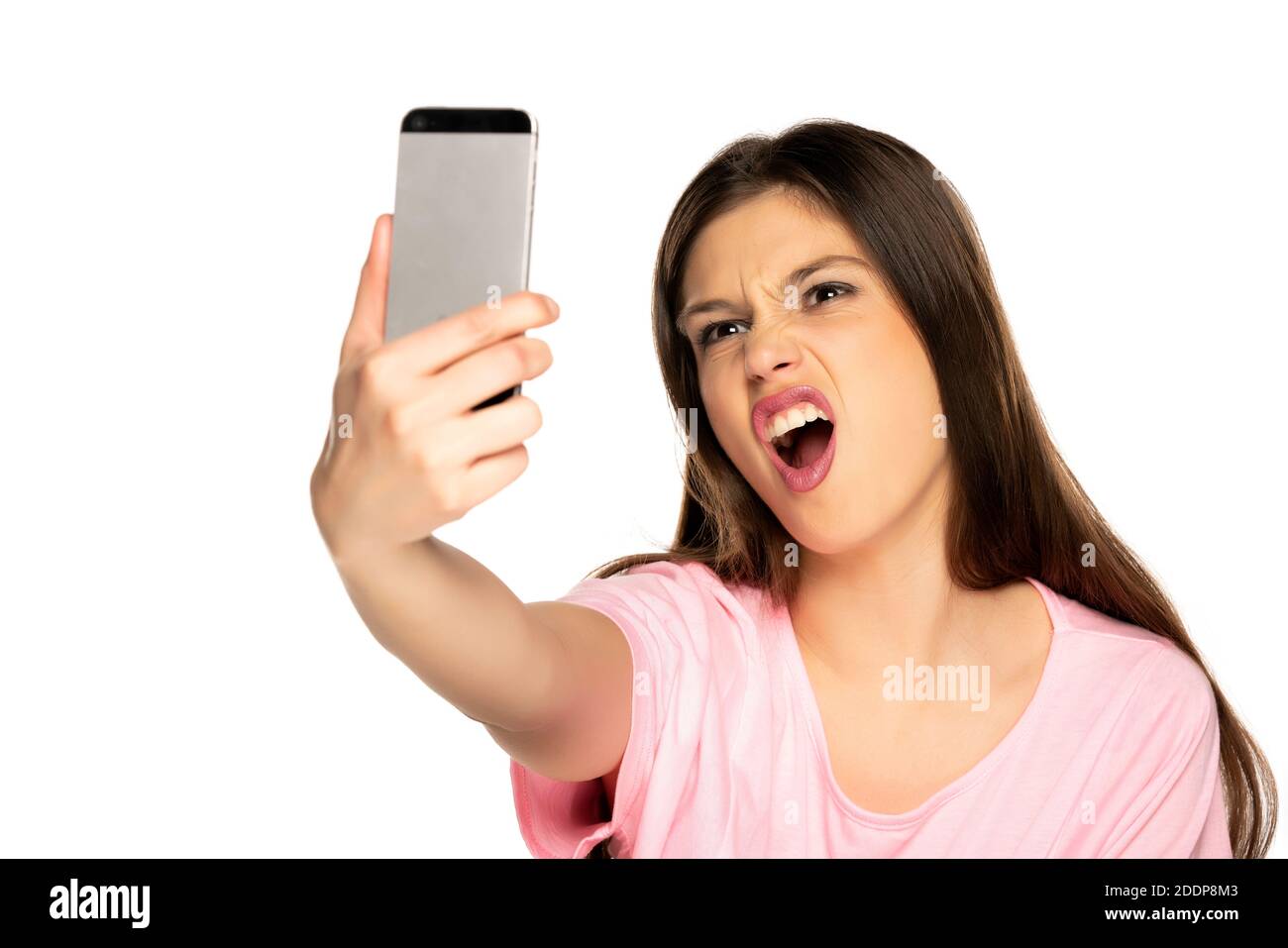 Woman taking selfies and make funny faces on white background Stock