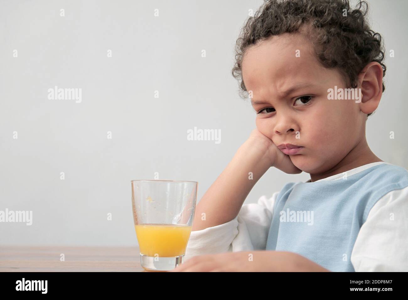 child drinking a glass of orange fruit juice promoting healthy eating