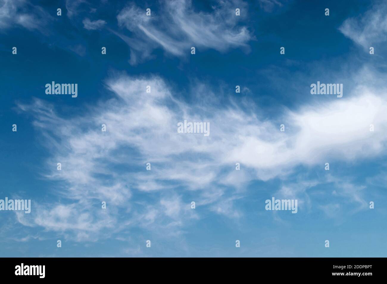 White feathery fluffy clouds on a blue sky, background and texture ...