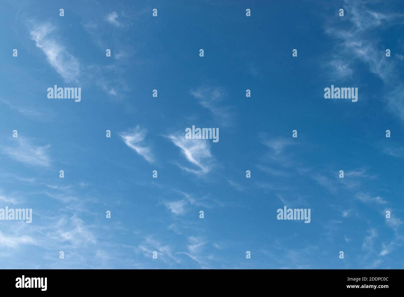 White feathery fluffy clouds on a blue sky, background and texture Stock Photo