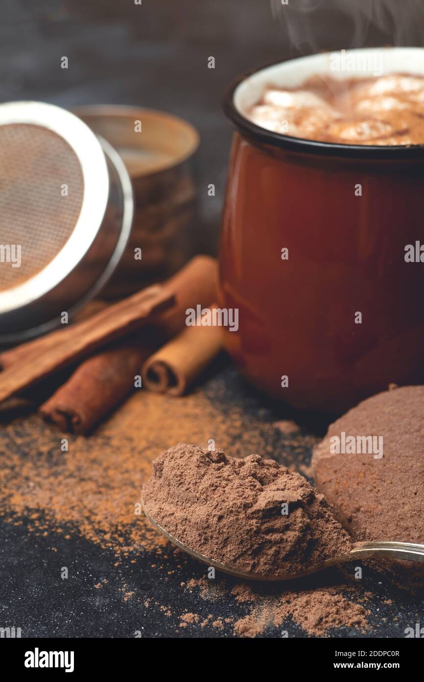 Hot chocolate (cocoa) drink backround. Cocoa drink on a dark background with cinnamon and whipping. Winter hot drinks Stock Photo