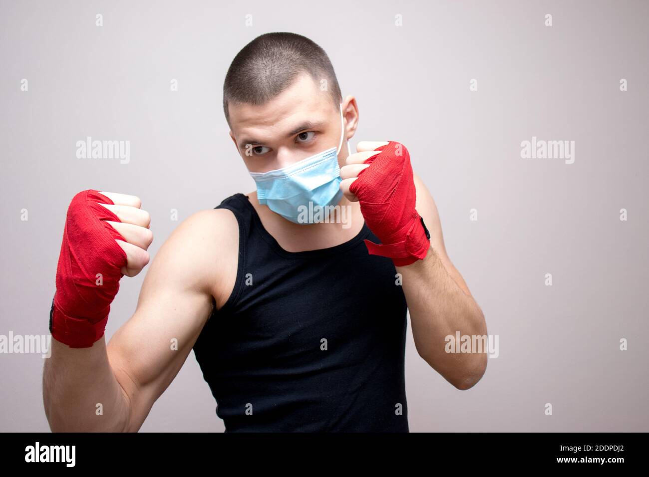 Young athletic male shadowboxing.Hand wrapped and wearing face mask ...