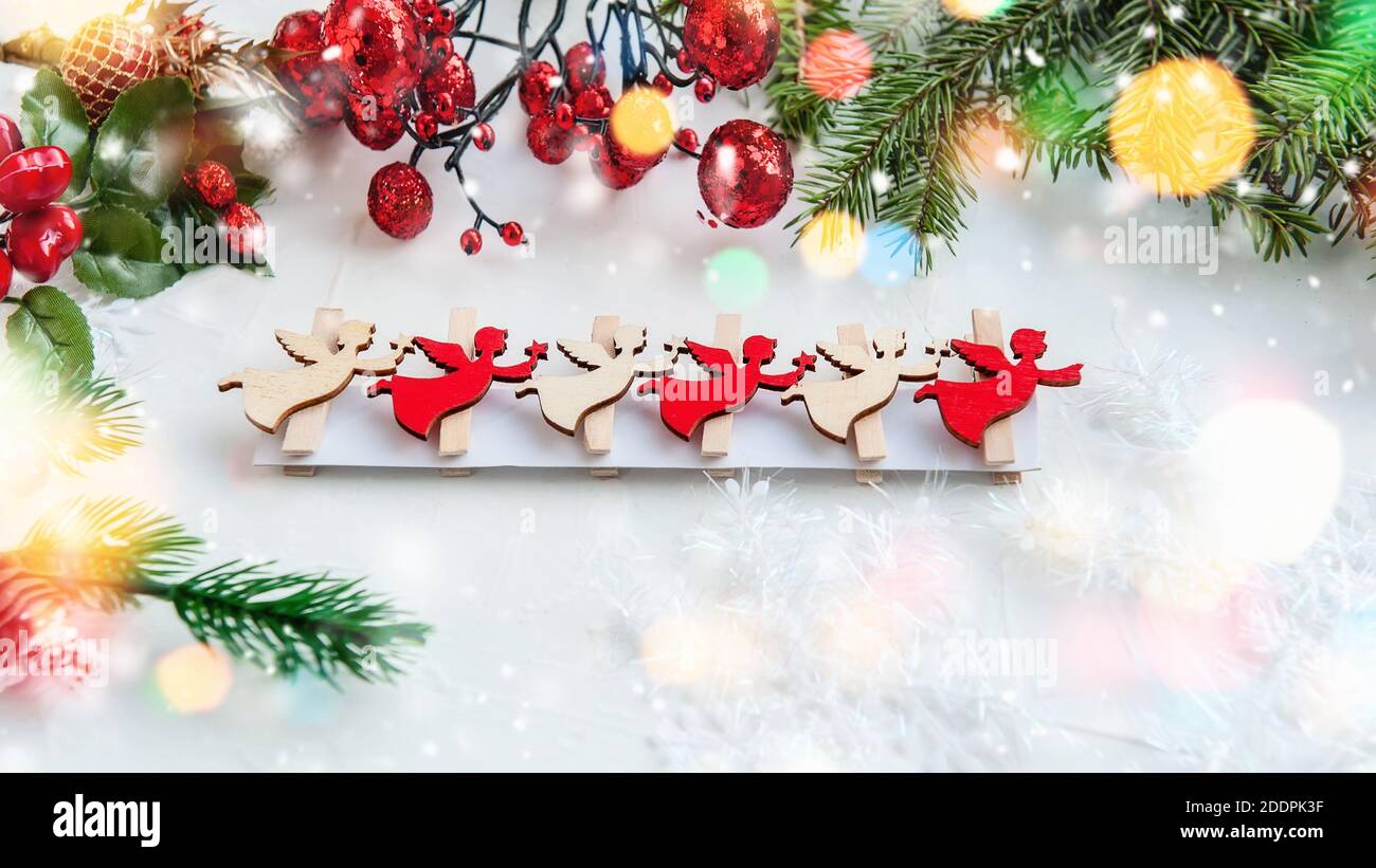 Christmas angels made of plywood, wooden ECO-decoration, toy. Christmas decorations with your own hands. Figures of flying angels in white and red on Stock Photo