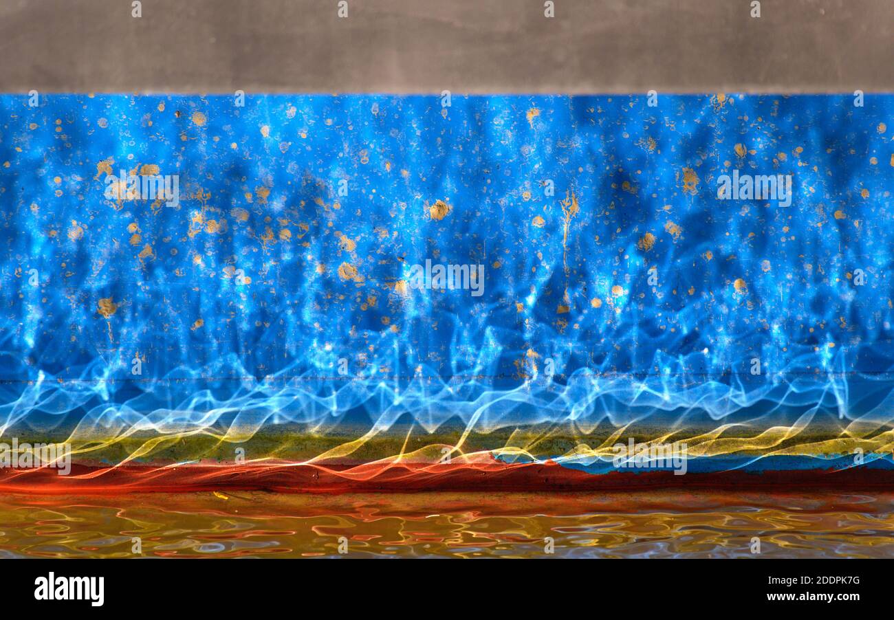 Light reflection of waves on a water surface mirroring on the blue ship