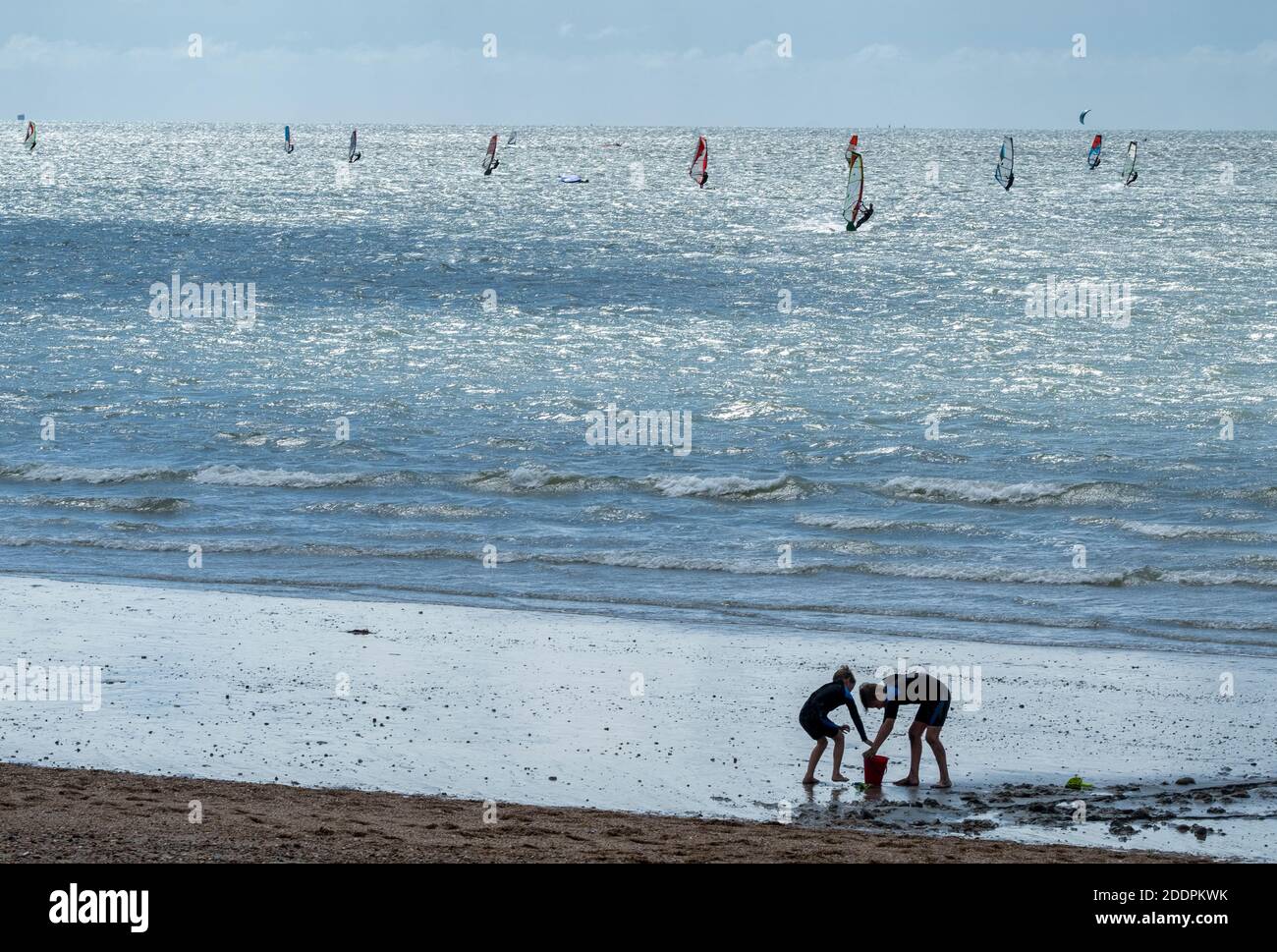 People of varying ages enjoying a sunny afternoon on a sandy beach and in the sea on Hayling Island, Hampshire, England UK Stock Photo